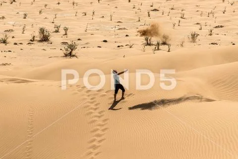Man tourist in desert rub al khali Oman throwing sand 4 Stock Photos