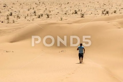 Man tourist desert rub al khali Oman running in sand Stock Photos