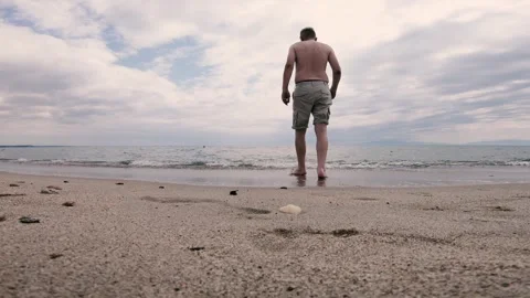 Man tourist enjoy walk on the beach on sunny hot summer day Stock Footage 315136853