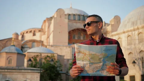 Man tourist looking at map against Ayasofya Mosque, travel concept Stock Footage 201530552