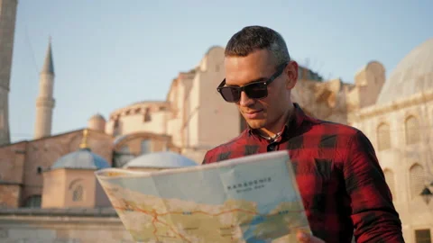 Man tourist looking at map against Ayasofya Mosque, travel concept Stock Footage 201804507