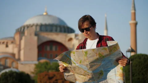 Man tourist looking at map against Ayasofya Mosque, travel concept Stock Footage 201804616