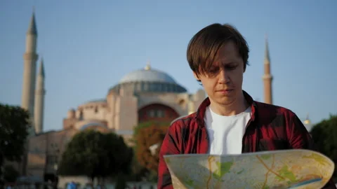 Man tourist looking at map against Ayasofya Mosque, travel concept Stock Footage 217437291