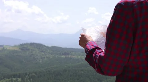 Man tourist in mountain read the map. Man on top of mountain. Tourism concept Stock Footage 68940415