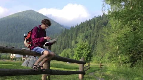 Man tourist in mountain read the map. Man on top of mountain. Tourism concept Stock Footage 68940483