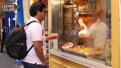 Man tourist in Paris Latin quarter buy greek gyros at street food point Stock Footage