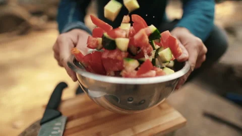 A man-tourist prepares a salad while hiking in nature Stock Footage 264141823