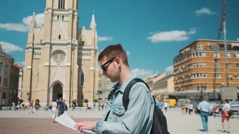 Man tourist with sightseeing map standing outdoors in the old town. Portrait of Stock Footage 274133405