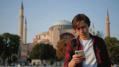 Man tourist using phone, navigating by city against Ayasofya Mosque Stock Footage 218374827