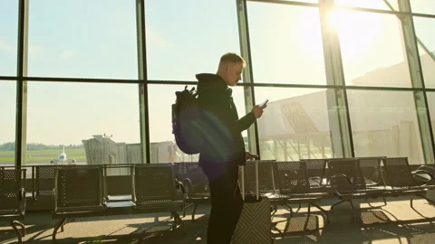 The man tourist using smartphone typing texting message with luggage in airport Stock Footage 154314095