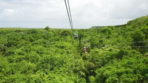 Man tourists having fun a on zip line above dense tropical rainforest Stock Footage 206399272
