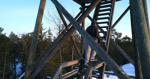 Man in a tower, Cinema 4k view of a young male climbing to a watchtower, on a Stock Footage 86296506