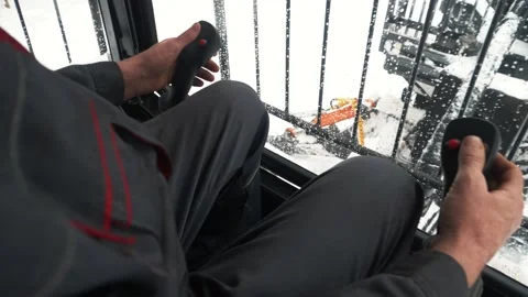 A man in the tractor cab controls two joysticks of a crane for a log loader Stock Footage 169548658