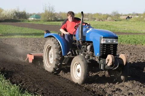 Man on the tractor in the field Stock Photos