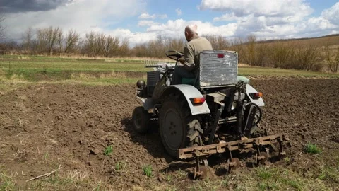 A man on a tractor plows the ground Stock Footage 181985225