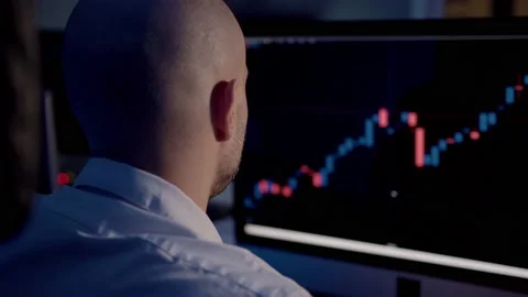 Man trader back view analysing stock market charts on the screen Stock Footage 159558445