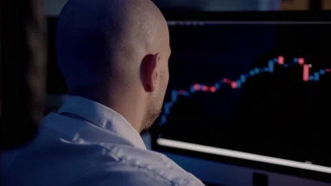 Man trader back view looking at the screen with stock market graphs 스톡 동영상 159359585