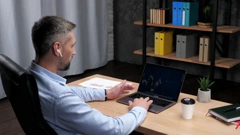 Man trader broker talks to potential investor uses laptop stock exchange chart Stock Footage 169033260