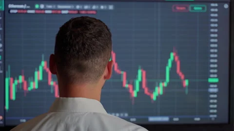 Man trader looking at graph currency money at screen indoors Stock Footage 157455294