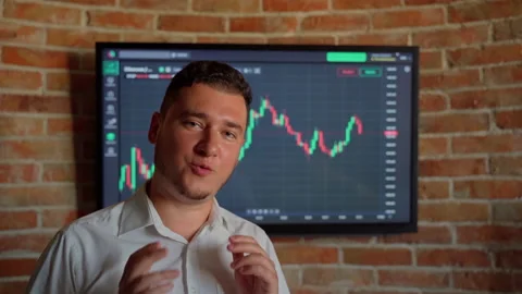 Man trader talk looking at camera graph finance background indoors Stock Footage 157455622