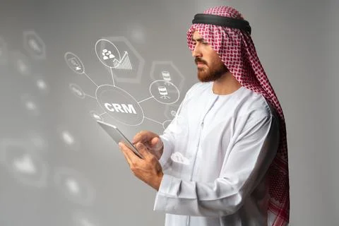 Man in traditional attire using tablet to manage CRM data and tools for cus.. Stock Photos