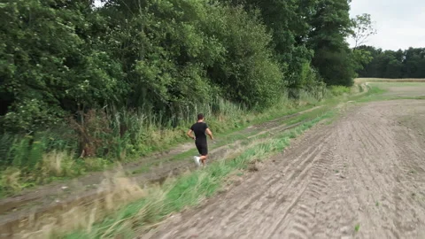 Man trail running along a muddy path during an outdoor workout Stock Footage 346533609