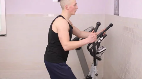 Man train on an elliptical trainer Stock Footage 60944922