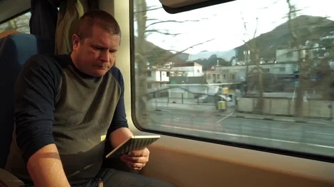 The Man In The Train Near a Window Reads The E-Book Stock-Footage 73017292