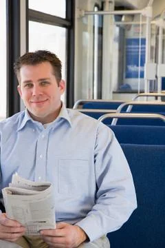Man on train with newspaper Stock Photos