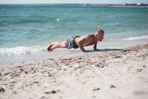 Man in training on beach Stock Photos
