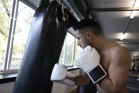 Man training boxing hitting punching bag in gym Stock Photos