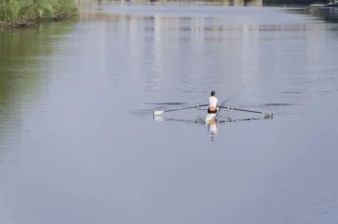 Man training on canoe to practise rowing during early morning on river Stock Photos