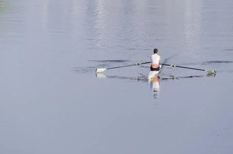 Man training on canoe to practise rowing during early morning on river Stock Photos