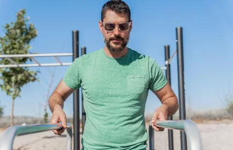 Man training his arms on parallel bars Stock Photos