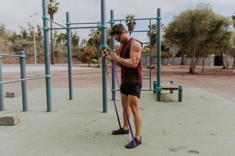 A man is training his biceps with an elastic band during a workout session .. Foto stock