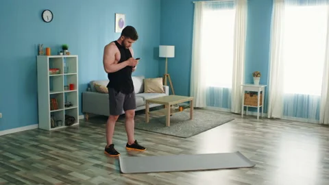 Man Is Training at Home Using Smartphone Stock Footage 134888027