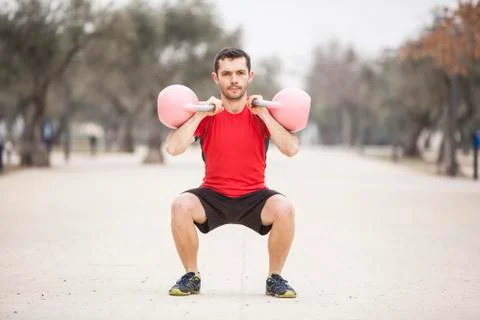 Man training with kettle bell on squat in the park Stock Photos