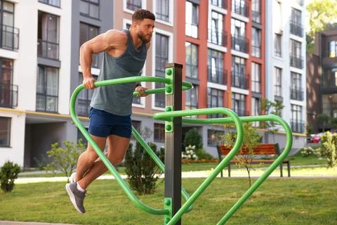 Man training on parallel bars at outdoor gym Stock-Fotos