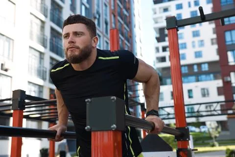 Man training on parallel bars at outdoor gym 스톡 사진