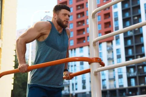 Man training on parallel bars at outdoor gym Stock Photos