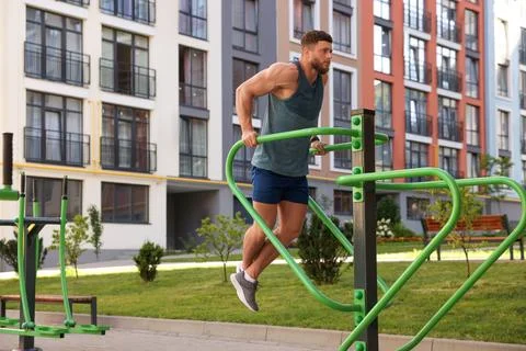 Man training on parallel bars at outdoor gym Foto stock
