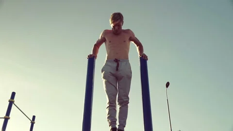 Man training on parallel crossbars Stock Footage 90932736