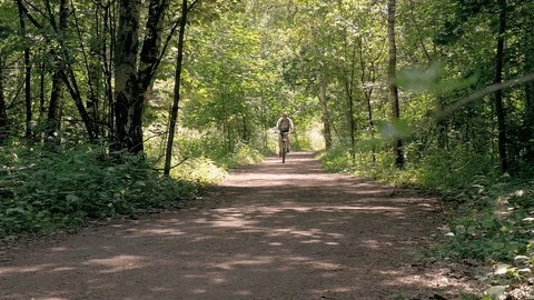 A man is training in the park. He rides a bicycle on a summer day, on special Video stock 91865455