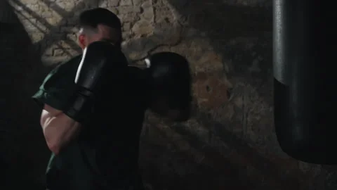 Man Training with Punching Bag in Dark Room Stock Footage 281666004