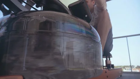 Man training in a rowing machine on the top of a building Stock Footage 171316551