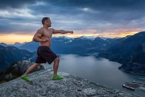 Man training on top of a mountain Foto stock
