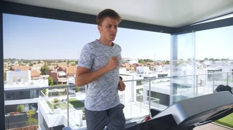 Man training on a treadmill on the top of a building Stock Photos