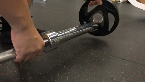 Man training using barbell.He loading weight for start. Stock Footage 99007958
