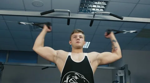 The man trains the biceps muscle on the block device Stock Footage 56867006