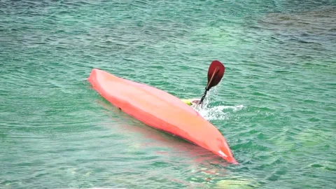 Man trains in kayak eskimo roll, slow motion. Kayak on turquoise sea water Stock Footage 248890147